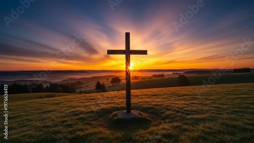 Cross on hill at sunset landscape.