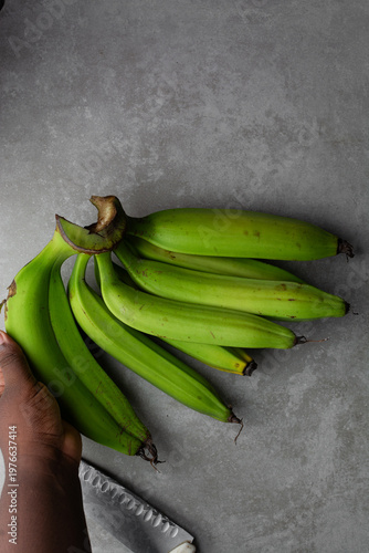 Photography Overhead view of unripe plantains on grey countertop, top view of green plantain
