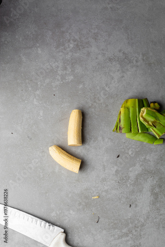 Quadro su tela Overhead view of sliced unripe plantains on grey countertop, top view of peeled