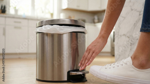 Wallpaper Mural Persons hand and foot near a stainless steel pedal trash can in a modern kitchen, demonstrating ease of use Torontodigital.ca
