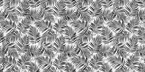 A seamless pattern of tropical palm leaves in black and white