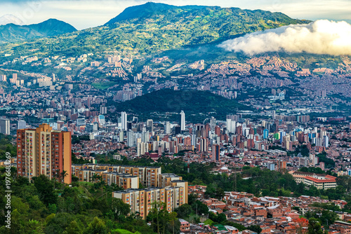 Panoramic Aerial View of Medellin Cityscape and Downtown Skyline Nestled in the Aburra Valley Surrounded by Green Andes Mountains under a Cloudy Sky - Colombia South America