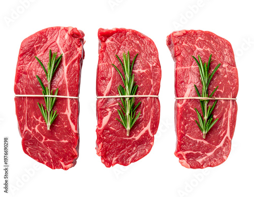 Raw beef steaks tied with string and fresh rosemary sprigs