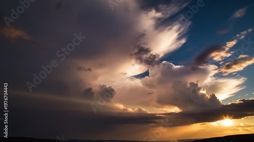 Dramatic sky with powerful clouds and golden sun rays at sunset