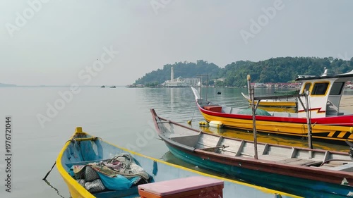 Traditional fishing willage with the boats and the floating mosque on the background in Pangkor island, Malaysia