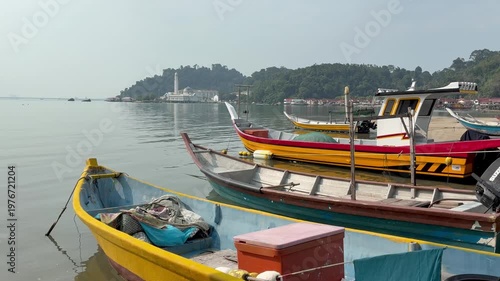 Traditional fishing willage with the boats and the floating mosque on the background in Pangkor island, Malaysia