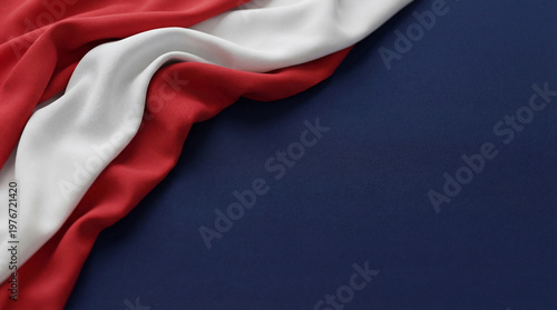 Φωτογραφία Elegant drape of red and white fabric on a deep blue background, creating a visually dynamic abstract composition