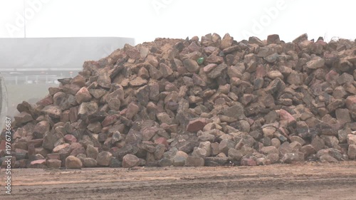 ​Heap of nice cobblestones, unloaded at a construction site. Gravel, granite stones, bout on the open construction site. Preparation for the construction of a new highway