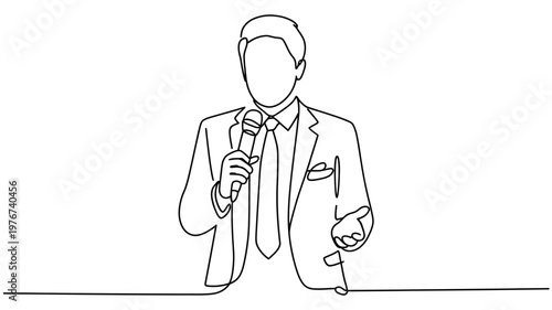 A confident male speaker in a formal suit is holding a microphone and addressing an audience.