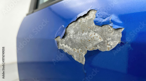 Car accident insurance estimate, blue car door, peeling paint, rust damage, body repair, closeup detail shows car insurance