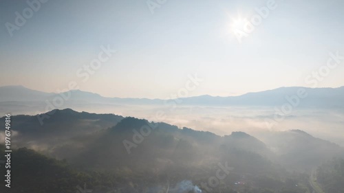 Hyperlapse by drone Spectacular aerial view of a sea of mist covering mountain ranges under a bright morning sun. Captures peaceful nature, morning fog, and scenic horizons at sunrise.