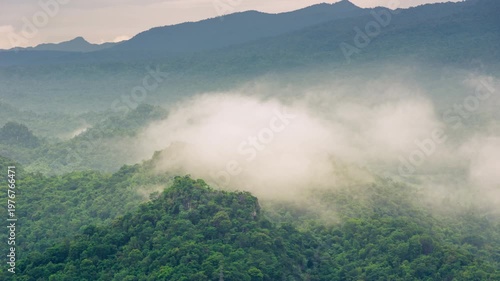 4K video of an aerial view of beautiful clouds or fog moving over the mountain peaks in northern Thailand.