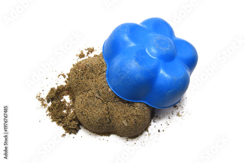 Wet sand is formed with plastic toy into flower shape