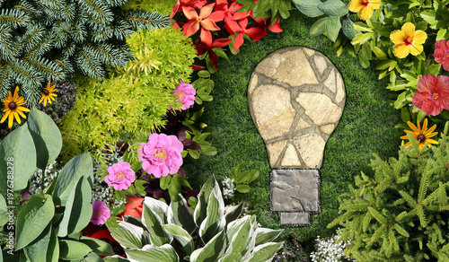 Gardening Ideas and garden Background with an ornamental landscaped flowerbed and spring gardening concept shaped as an idea lightbulb with a mowed lawn and grass representing environmental design or 