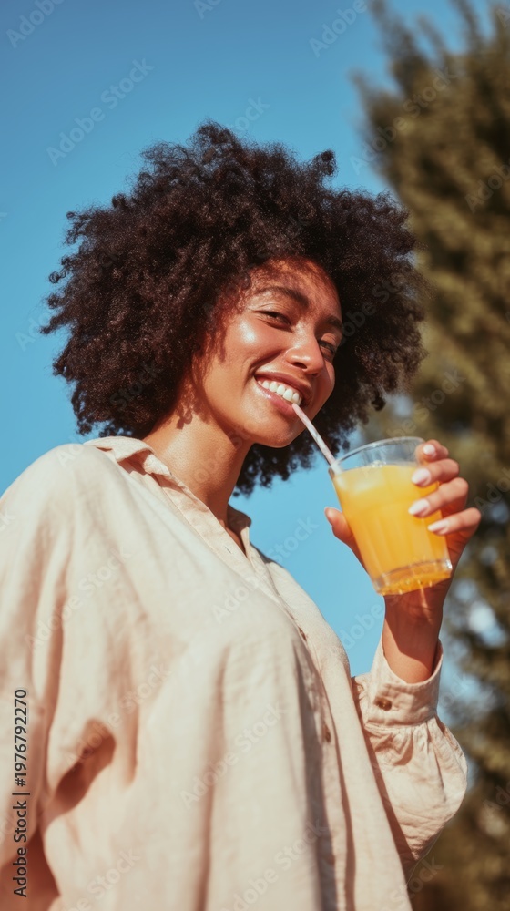 Fototapeta premium Happy Woman Enjoying Orange Juice on a Sunny Day