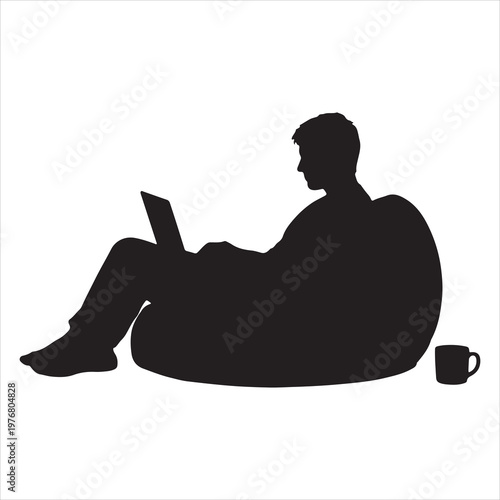 A man sitting on a beanbag chair with a laptop
