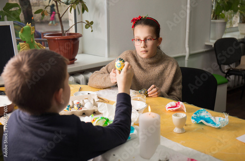 Photos Boy showing decorated Ukrainian pysanka egg to girl during craft lesson