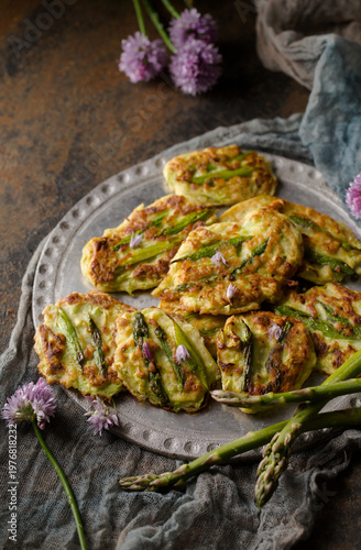 Homemade spring pancakes with fresh asparagus on rustic plate