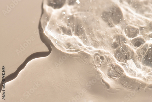 Cosmetic texture of gel, transparent serum on beige background, top view.