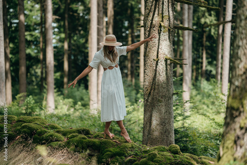 Quadro em tela A woman walks peacefully on a mossy stone wall in the forest enjoying nature and
