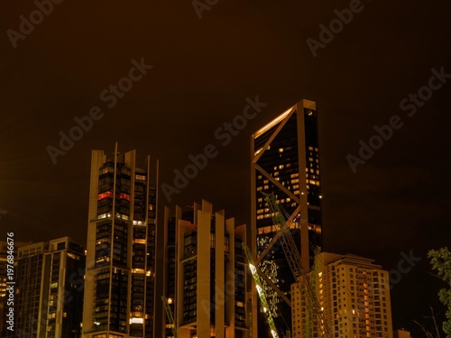 Low angle of skyscraper buildings in Kuala Lumpur at night.