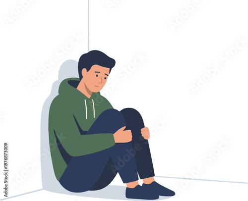 A man sits alone in a corner, looking sad and dejected.