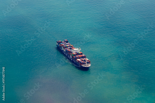 CMA CGM container ship navigating through turquoise blue ocean water. Global logistics and international maritime trade featuring cargo vessel in open sea.