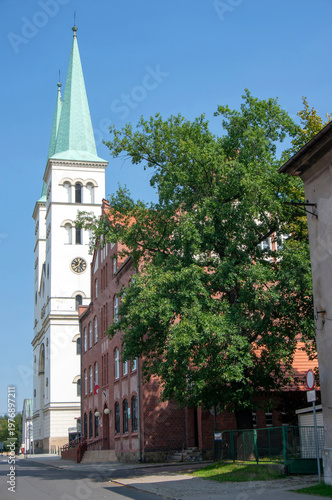 Kardynała Stefana Wyszyńskiego Street, towers of Basilica of Saint Adalbert (Bazylika  świętego Wojciecha). Mikołów, Poland.