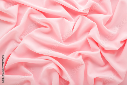 Pastel light pink soft wrinkled gabardine elastane fabric background. Closeup. Top down view.