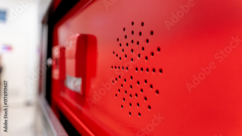 Tableau sur toile close up view of a red fire alarm control panel featuring a circular speaker gri