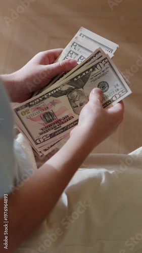 Child holding and counting new 50 US dollar bills, kid sorting fresh banknotes, money skills and savings. Hands with USD