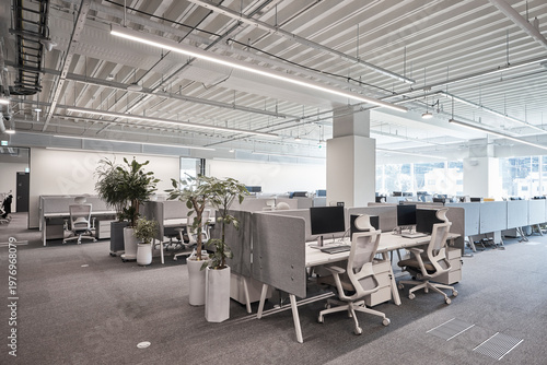 фотографія Open office with workstations beneath exposed ceiling in bright workplace