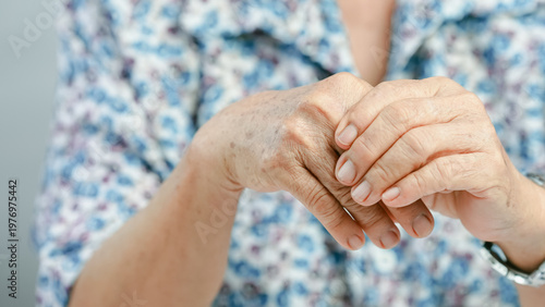 Close up senior woman with hand joint pain and stiffness. Elderly female holding fingers with discomfort, healthcare concept of arthritis, chronic inflammation, aging and medical treatment.