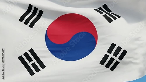 A national flag with a red and blue circle waving against a clear blue sky
