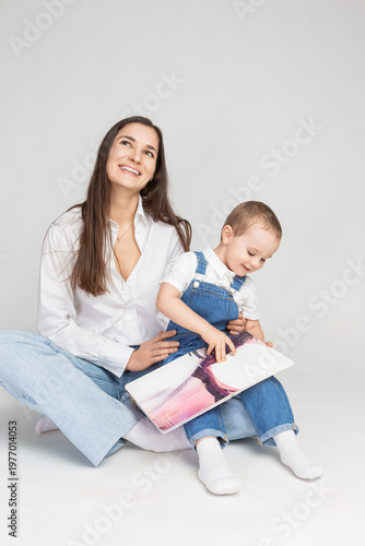 Adorable Smiling Cheerful Happy Couple Woman And Child Boy In Casual Clothing Having Mommy Little Kid Son Hug Cuddle Reading Book Together on White.
