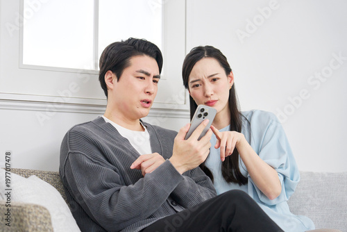 Fényképezés リビングでスマホを見て悩むカップル