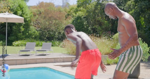 Father and teenage son in trunks walking poolside, gesturing son entering, learning, copy space