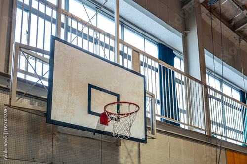 自然光が差し込む体育館のバスケットゴール