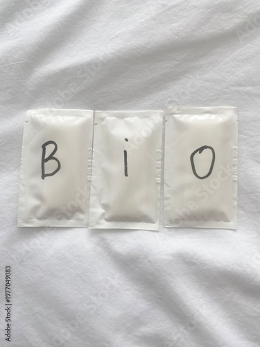 Wet wipe sachets with “BIO” text on fabric background, eco friendly hygiene concept