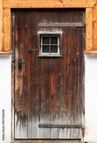 Rustic weathered wooden door with small window