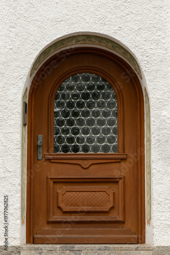Arched wooden door with circular glass block window