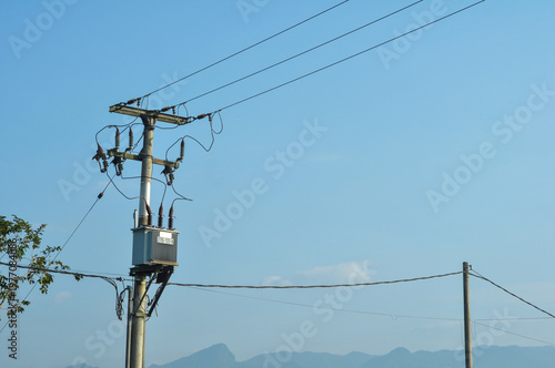Electric Power Pole with Transformer Against Blue Sky