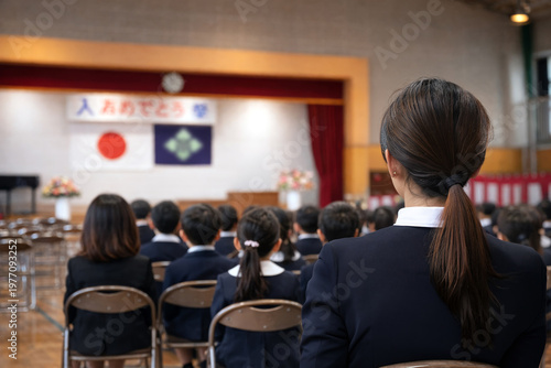 入学式で子どもを見守る母親の視点と学校の風景