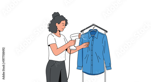 A woman with dark curly hair carefully uses a white handheld steamer to refresh a bright blue collared shirt hanging on a portable black garment rack.