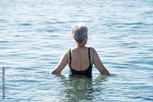Senior Woman Swimming in Calm Sea
