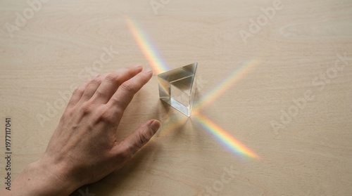 Hand Reaching For Light Refracting Through Glass Prism Representing The Spectrum Of Hope

