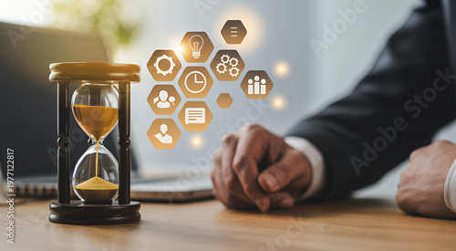 Businessman hand near hourglass with floating business for time management and strategy planning