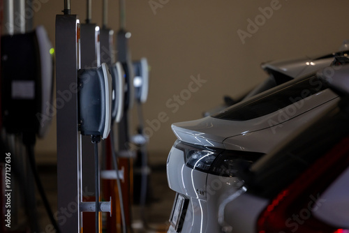 Electric vehicle charging at a station, cable connected, showing clean energy in use.