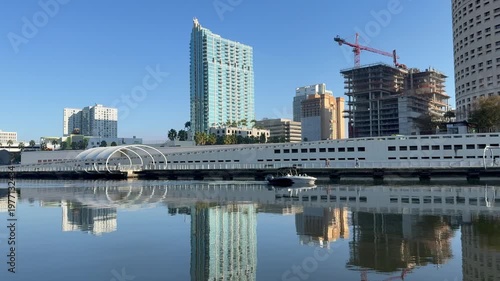 Tampa riverwalk. Panoramic, scenic view of Downtown Tampa skyline. Boat sails through Hillsborough river. Waterfront Park and Tampa Museum of Art in the background. Tampa, Florida 