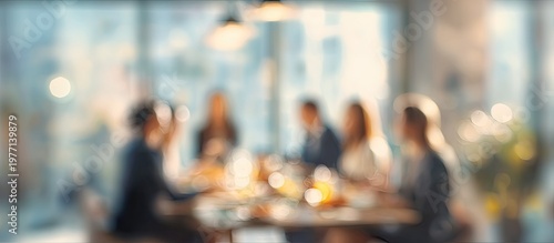 Blurred group of people dining at a table in a bright, modern restaurant setting